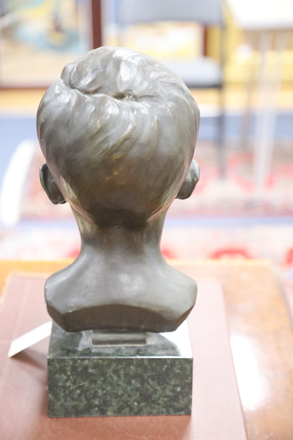 A bronze bust of a boy, signed R.Swann 1930, on marble base, height 38cm, some scuffing to the nose shows some white metal although we